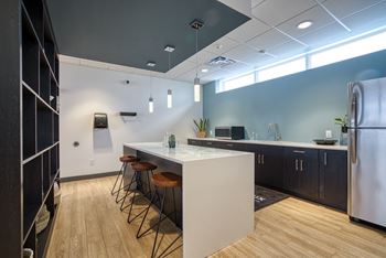 A kitchen with a white island and bar stools.